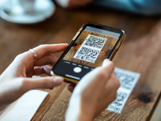 Young woman hands using the smart phone to scan the qr code